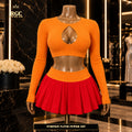 Pumpkin Patch Power Set on a curvy bronze RGC Viper mannequin, showing the pumpkin-orange ribbed keyhole crop top and red pleated mini skirt
