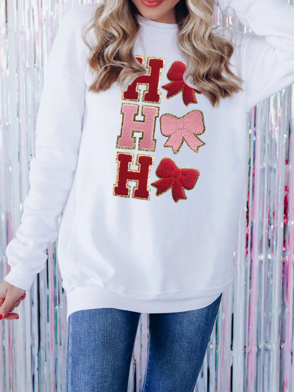Adult model wearing the beige long-sleeve embroidered pullover with jeans, front view.