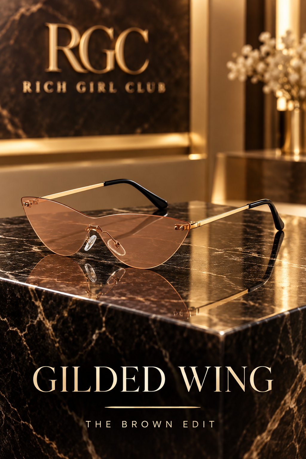Gilded Wing Brown rimless cat-eye sunglasses on a black marble pedestal