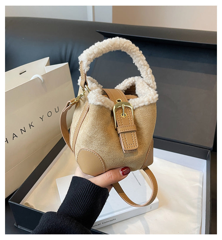 Khaki Plush Agenda Mini Messenger Bag held in hand, front view showing the cream plush trim, top handle, shoulder strap, and buckle tab.