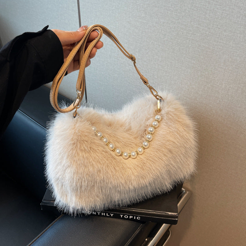 Beige plush shoulder bag with pearl-style front row and adjustable single strap, close product view.