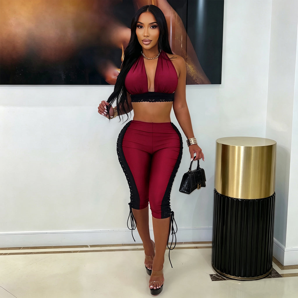 Model wearing wine-red After Hours halter crop top and matching lace-up capri pants, front view indoors
