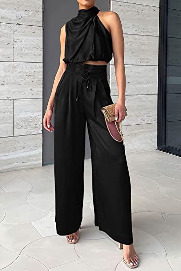 Model wearing the black draped sleeveless crop top and matching wide-leg trousers, full front view.