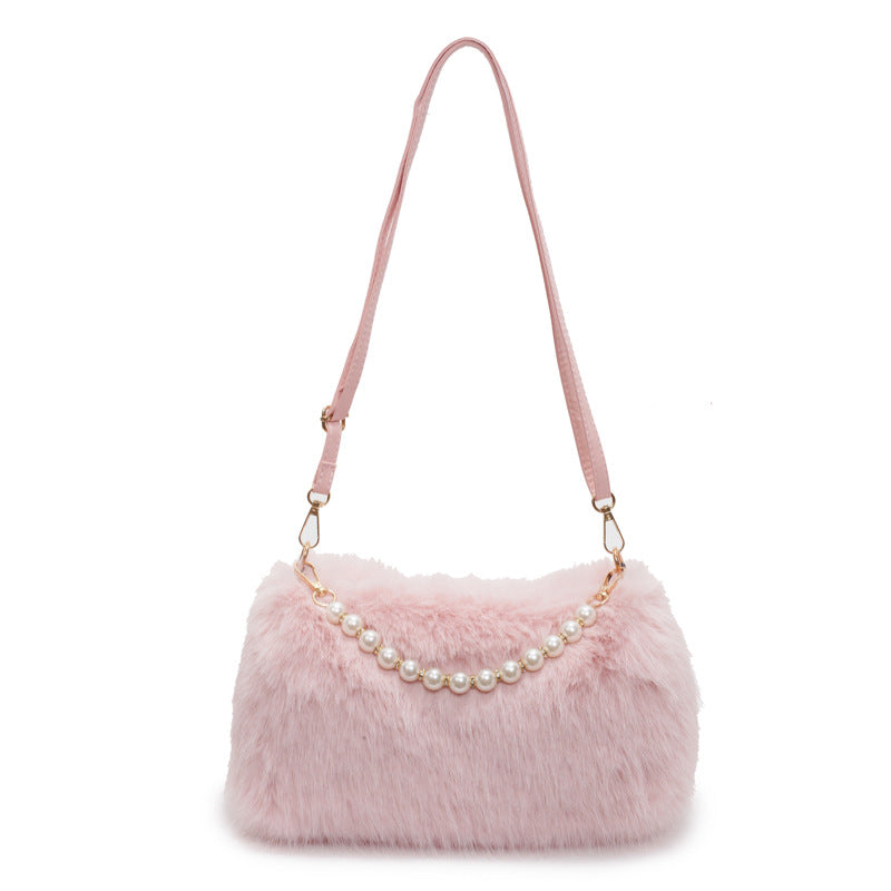Pink plush shoulder bag with pearl-style front row and adjustable single strap on a white background.