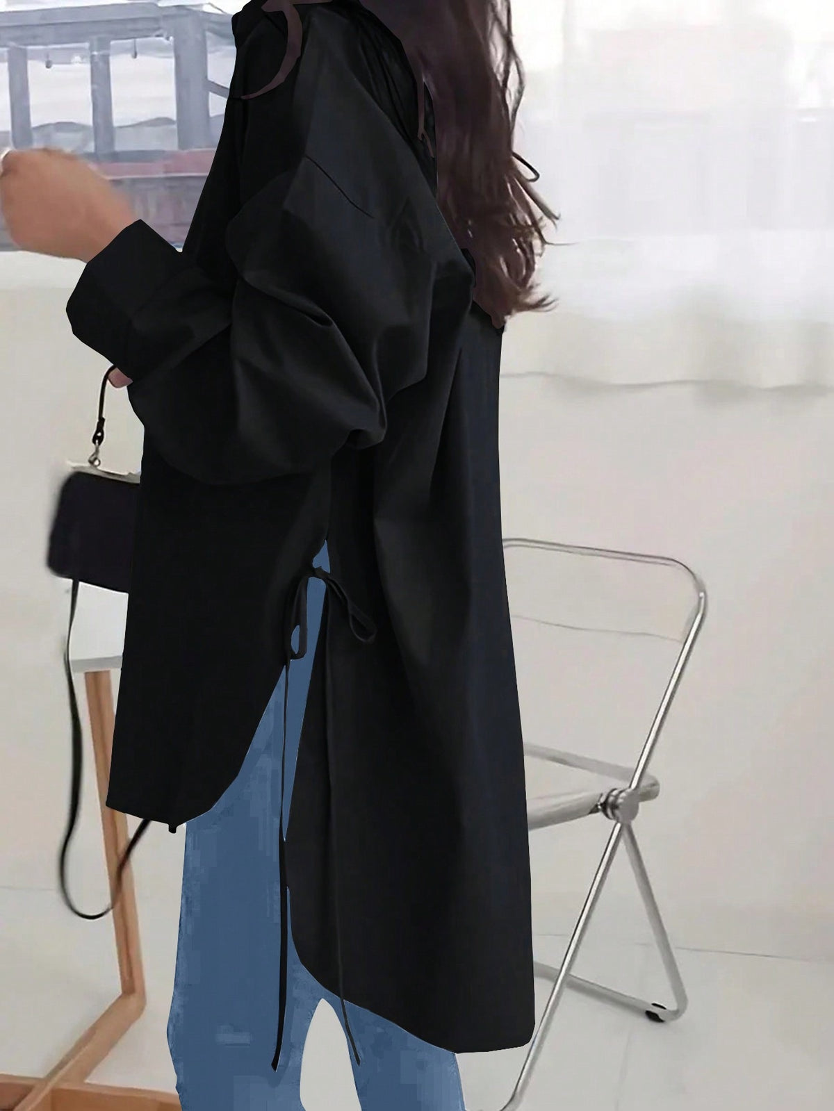 Side view of the black Off-Duty Luxe longline shirt showing the adjustable side ties