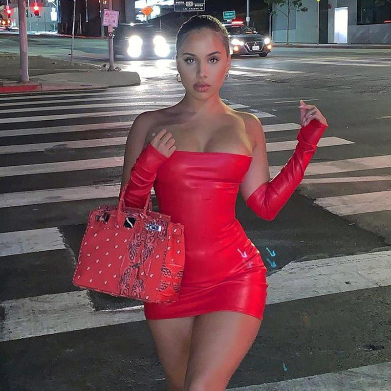 Adult model wearing the red After Dark Gloss Mini Dress on a nighttime city street; gloves and handbag are styling accessories and are not included.