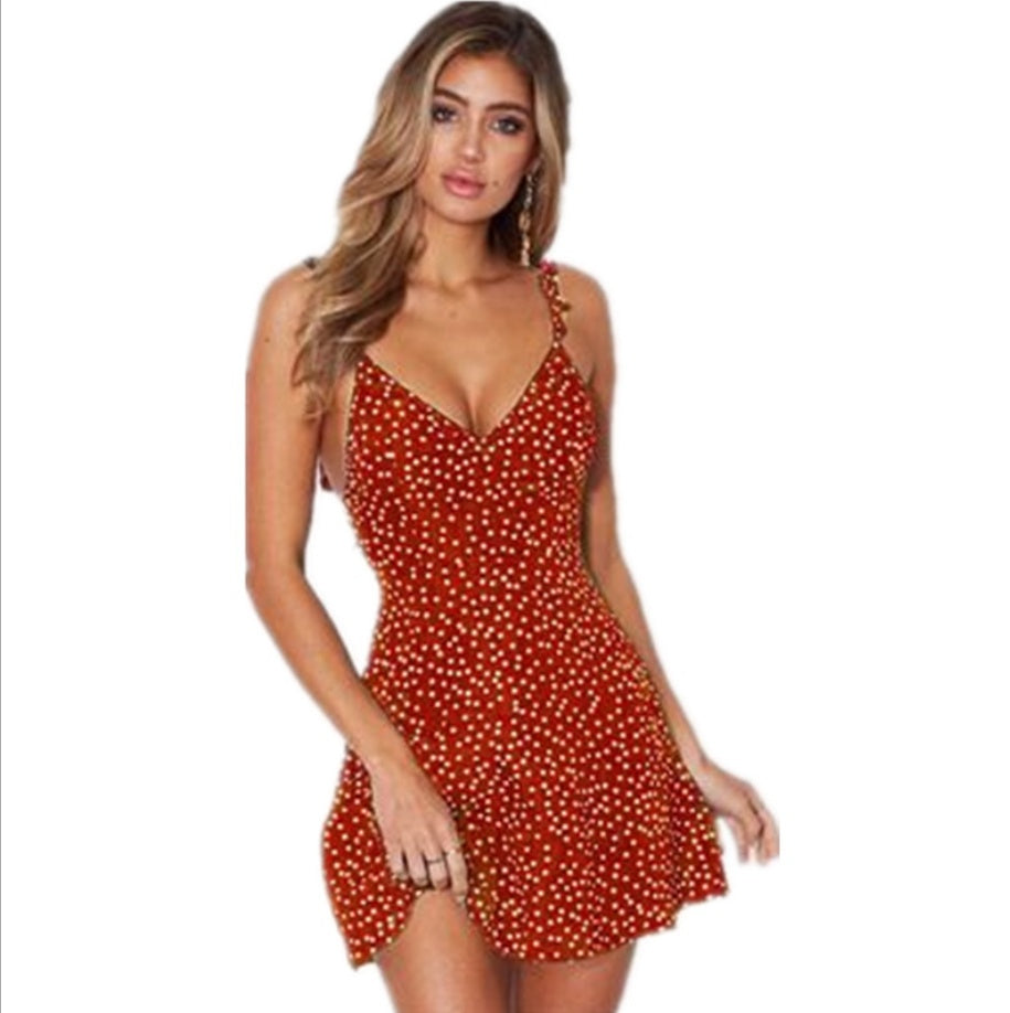 Front view of the red dotted V-neck sundress with ruffled straps and a flared hem.