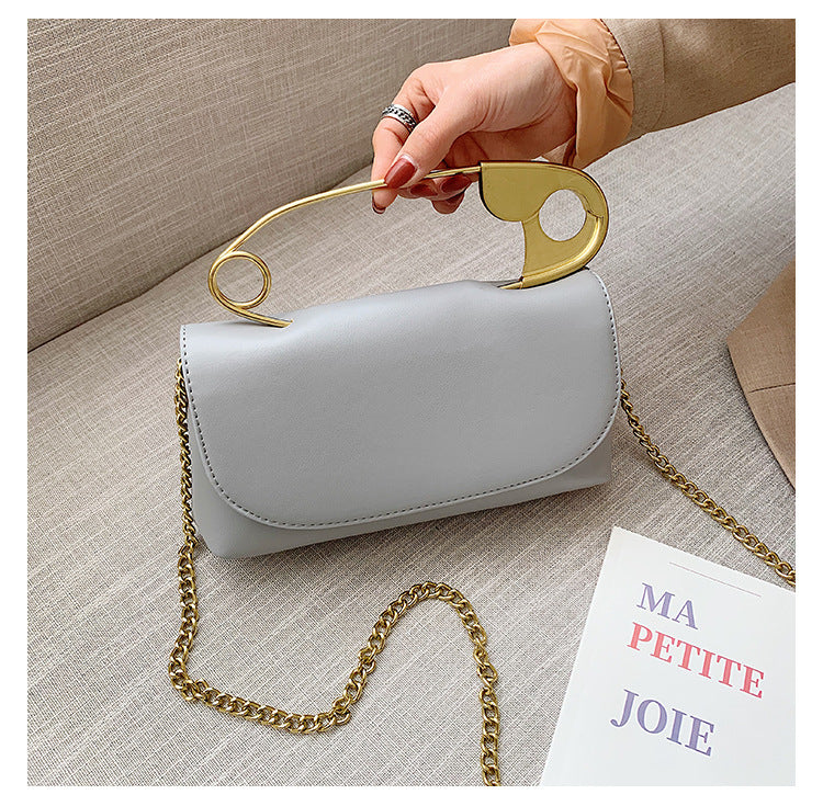 Grey Power Move Top-Handle Bag held by its gold-tone sculptural handle
