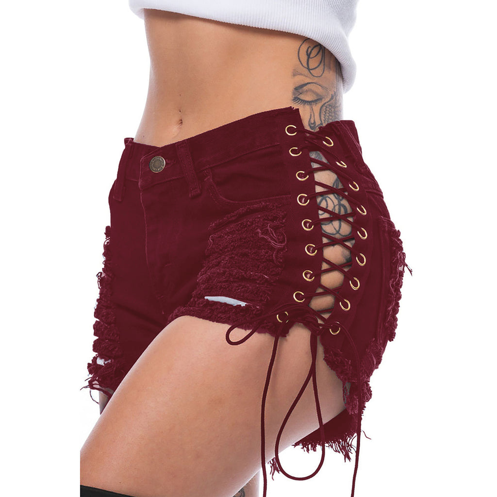 Close side-front view of wine-red distressed lace-up cutout shorts on an adult model.