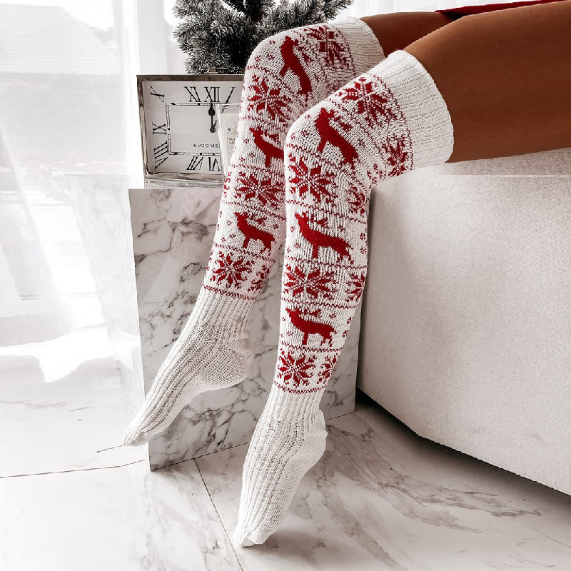 White acrylic knit over-the-knee stockings with red reindeer and snowflake pattern.
