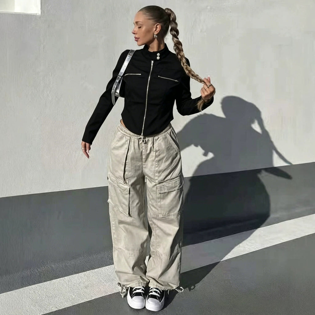 Adult model wearing the black Silver Circuit Zip Jacket with light cargo pants in an outdoor setting.