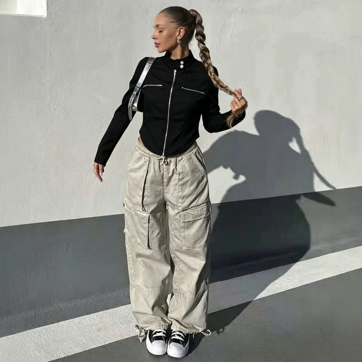 Adult model wearing the black Silver Circuit Zip Jacket with light cargo pants in an outdoor setting.