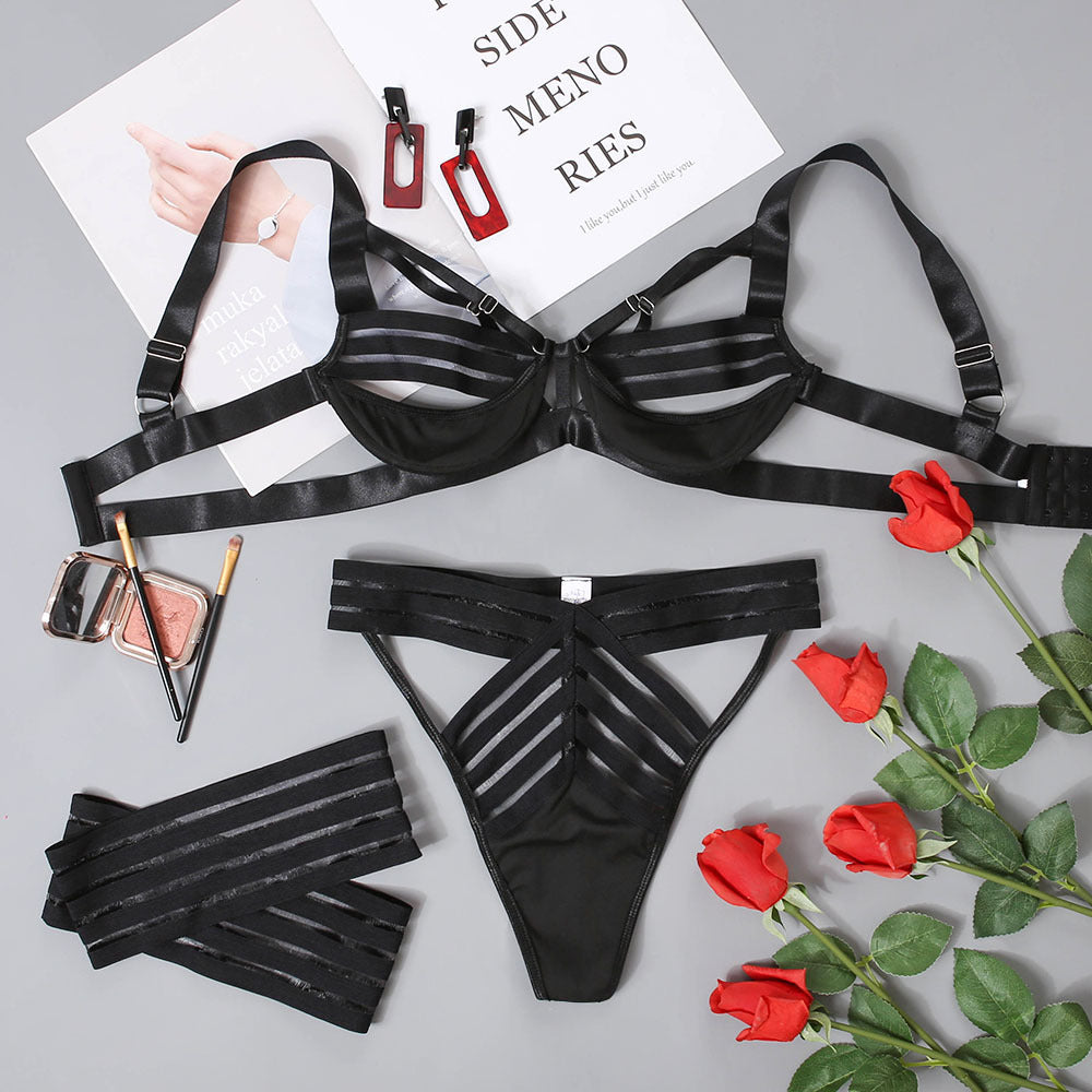 Ribbon Authority Lingerie Set flat lay showing the black bra, matching panty, and two leg rings.