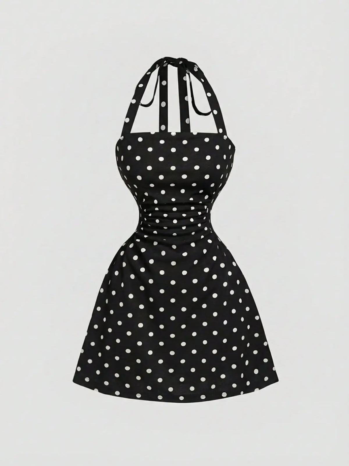 Black A-line mini dress with white polka dots, ruched waist and tie-back halter straps, front product view.