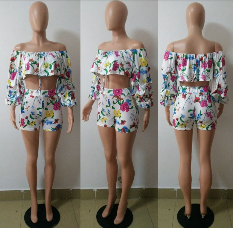 Adult model wearing the multicolor botanical-print ruffle top and matching shorts set with styled handbag.