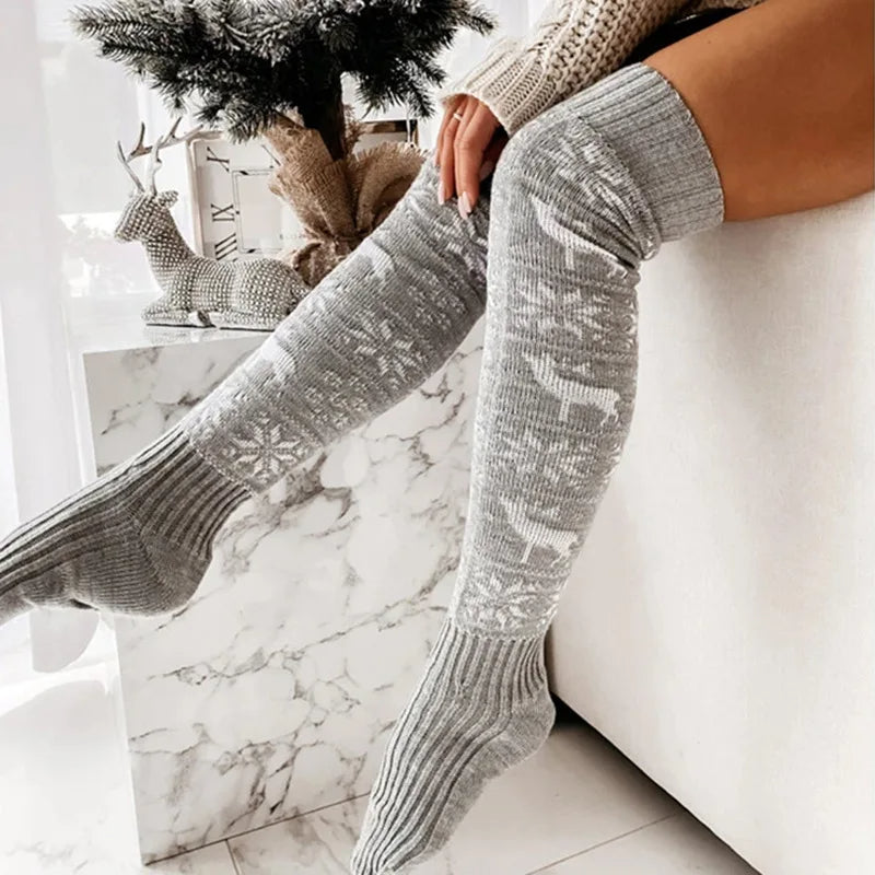 Close styled view of the gray reindeer-and-snowflake over-the-knee stockings.