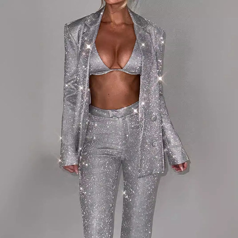 Close front view of the silver three-piece sequin suit showing the bra, jacket, and trousers.