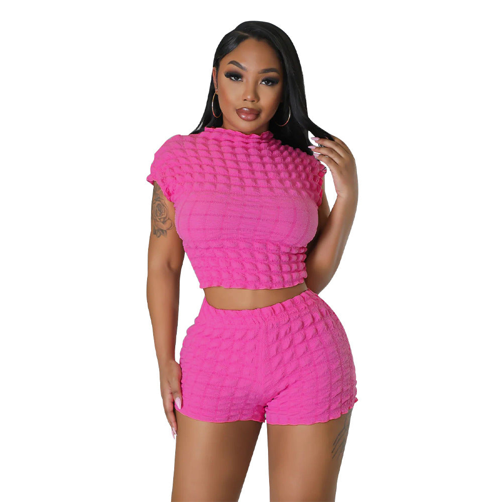Adult model wearing the rose-red bubble-texture crop top and matching shorts, front cutout view.