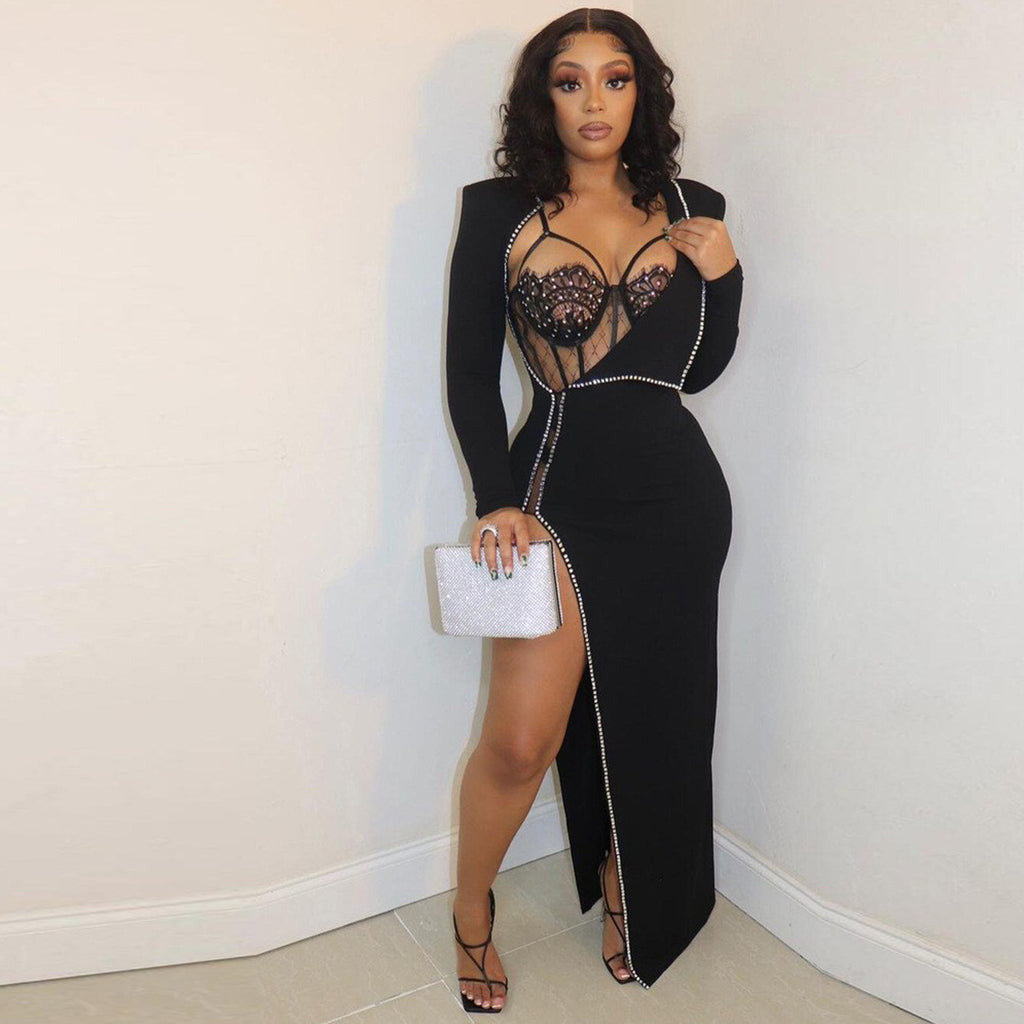 Model wearing the black Billion Moves Maxi Dress with long sleeves, jeweled sheer bodice, rhinestone trim, high thigh slit, and silver clutch.