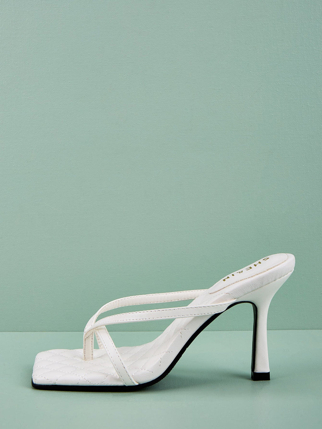 White sculpted strap mule heel side profile with quilted footbed