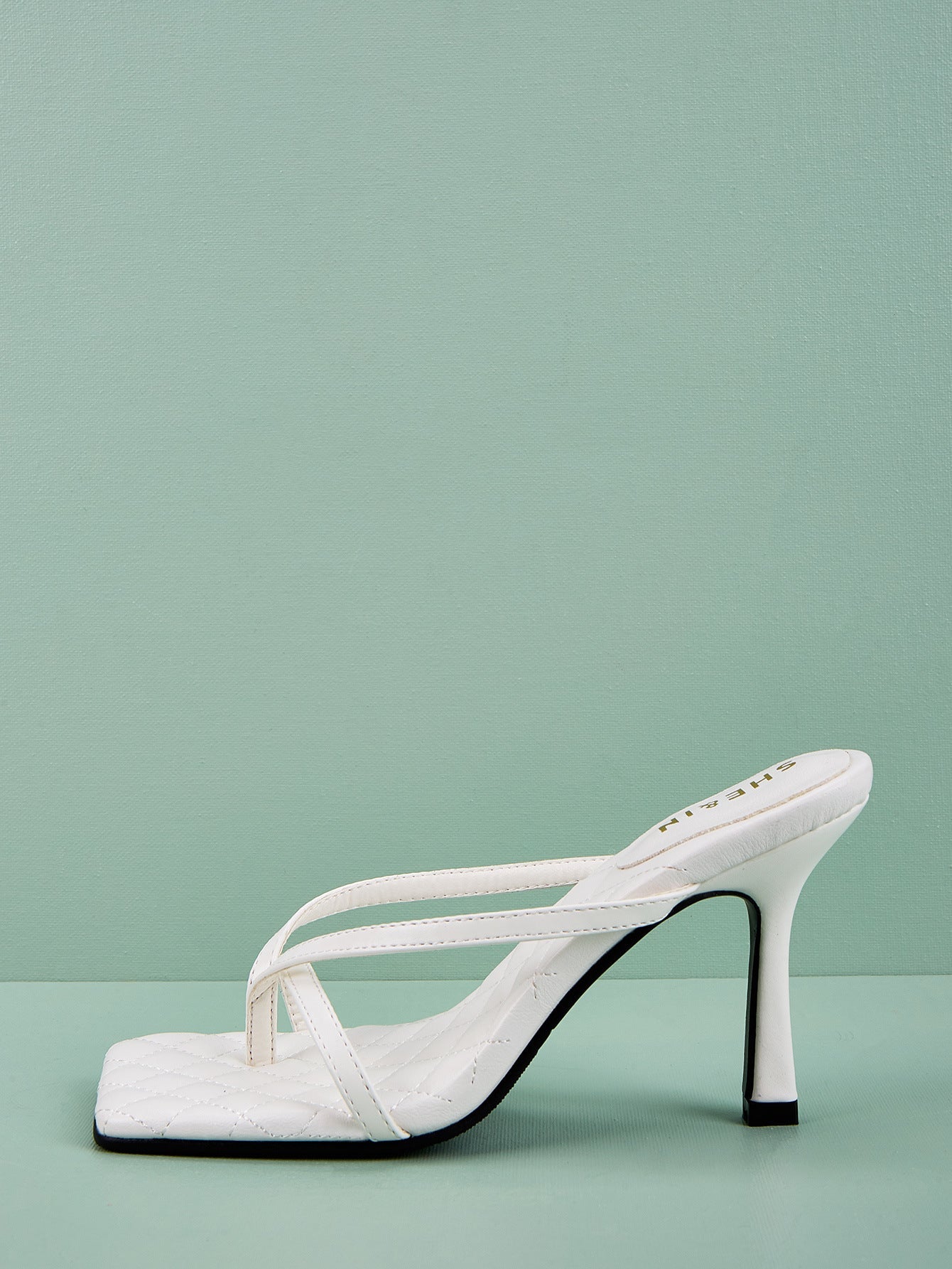 White sculpted strap mule heel side profile with quilted footbed