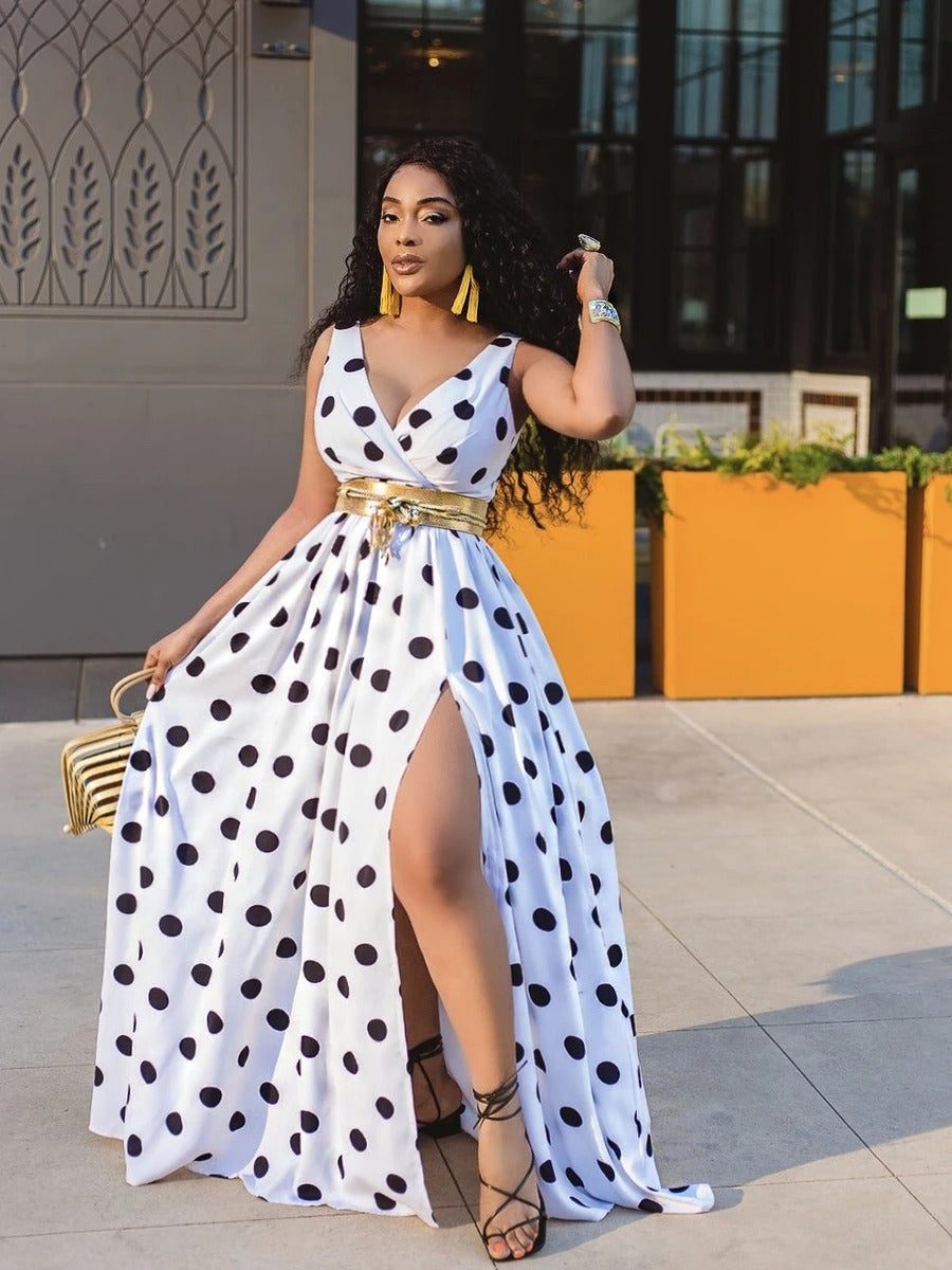 Adult model wearing the white-and-black polka-dot maxi dress with flowing skirt; belt and accessories are styling only.