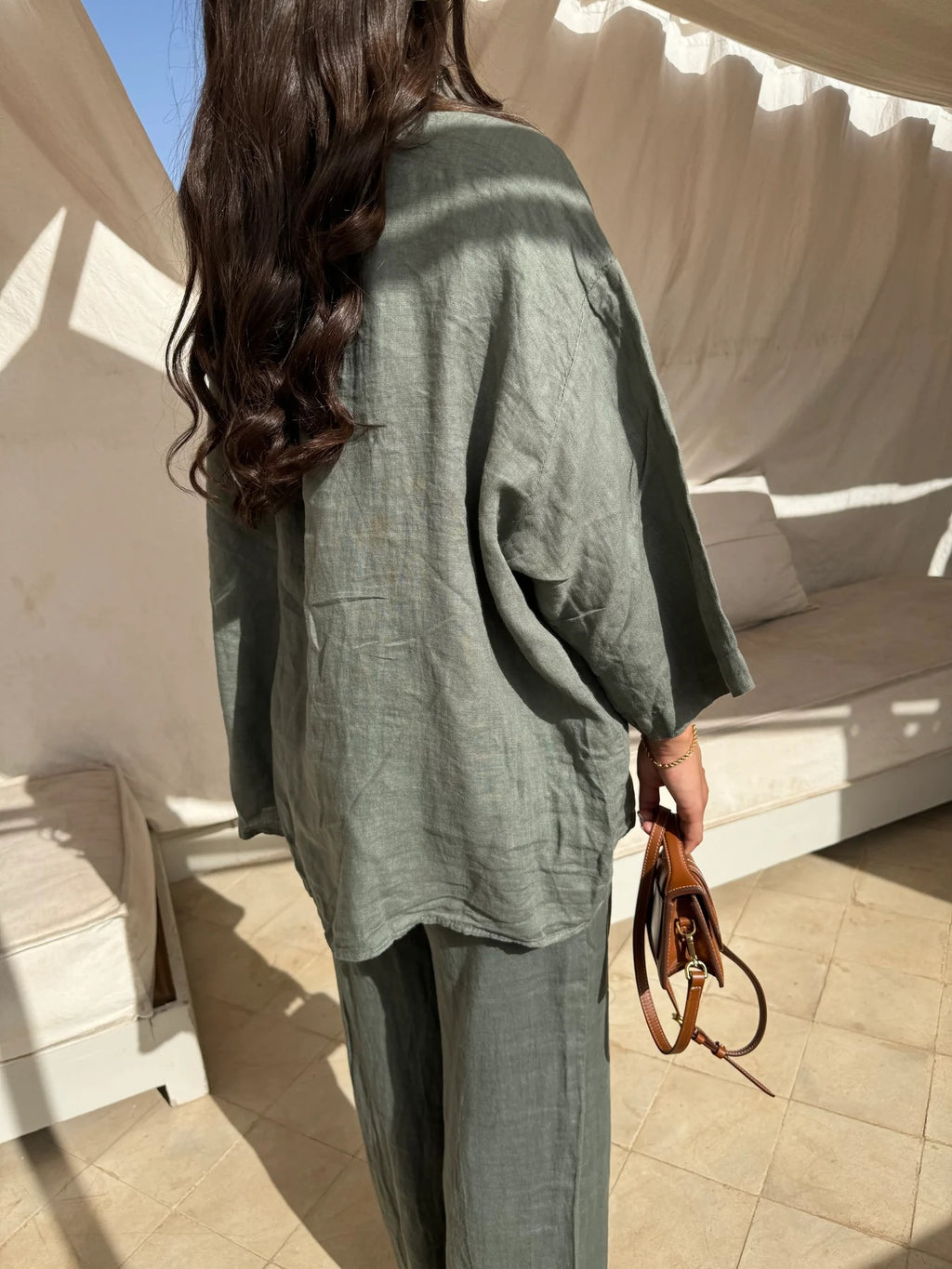 Rear detail view of the army-green relaxed shirt and matching trousers.