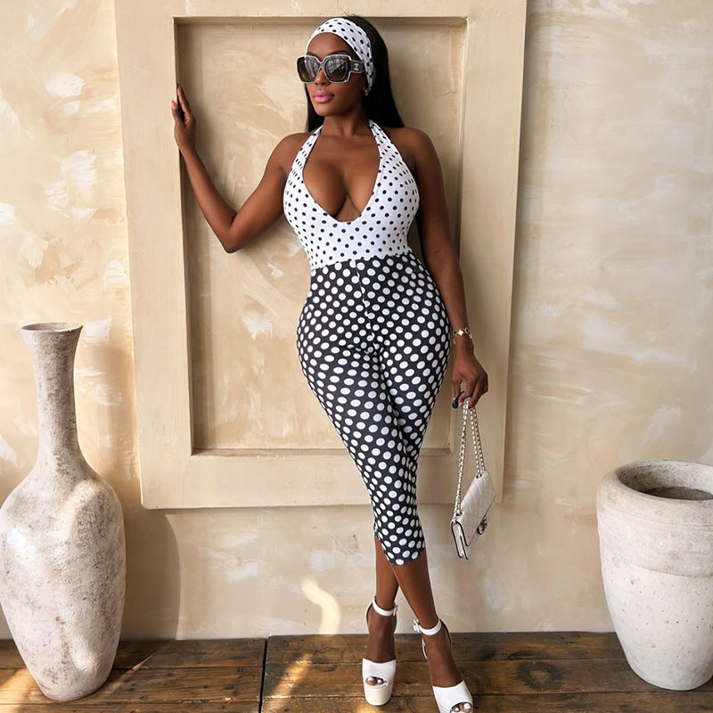Adult model wearing the black-and-white polka-dot halter jumpsuit, full front view; accessories are styling only.