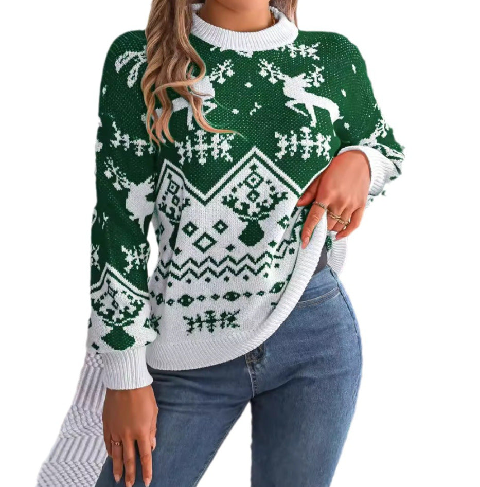 Adult model wearing the green and white Merry Main Character Reindeer Sweater, seated front view on a light background.