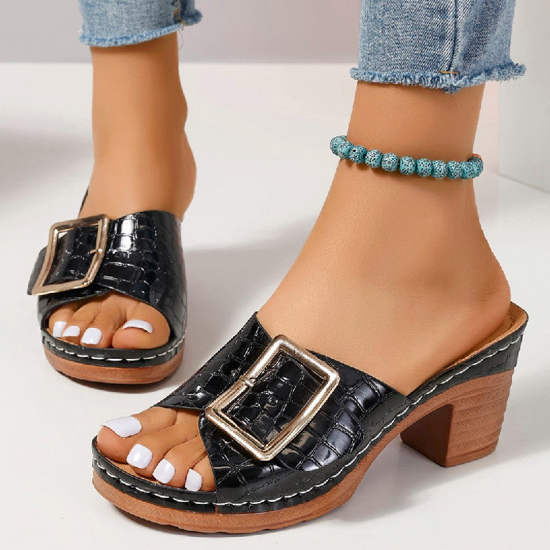 Adult model wearing the black croc-textured buckle slides, front three-quarter view.