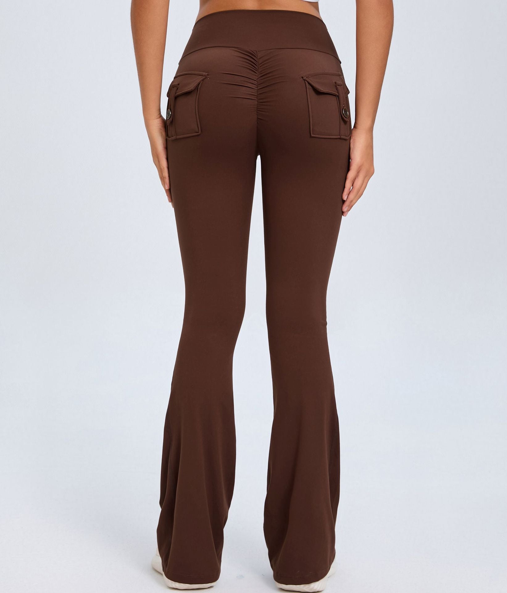 Brown high-waisted flare pants shown from the back with ruched seam and two buttoned flap pockets.