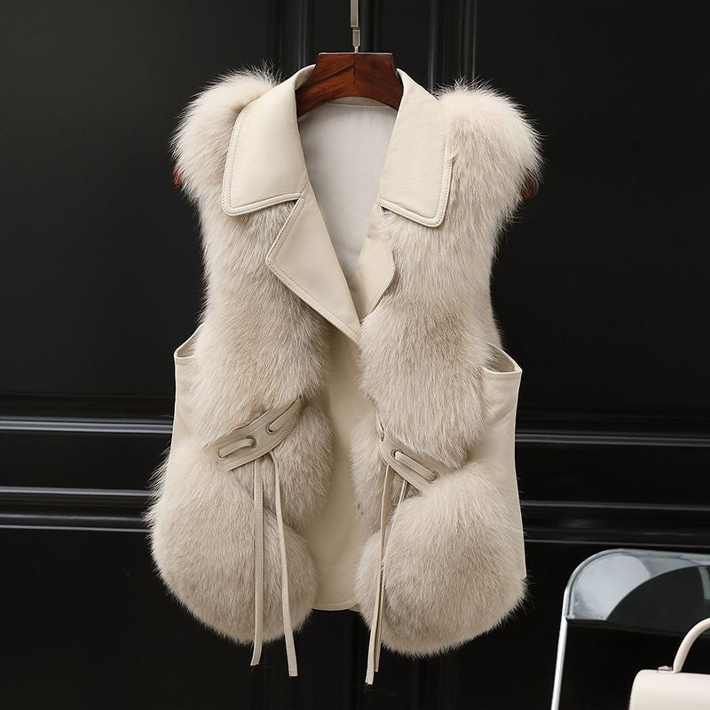 White Soft Power Faux-Fur Vest front view on a wooden hanger, showing wide lapels, button front, pockets, and tie accents.