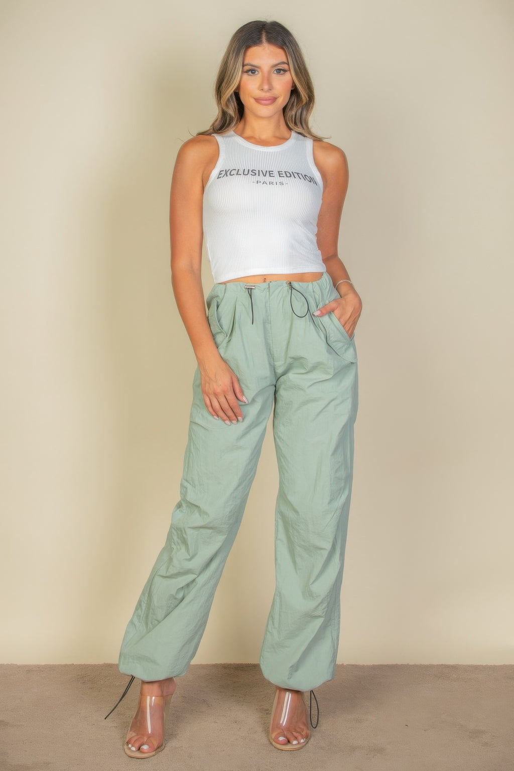 Full front view of the white Exclusive Edition Rib Tank Graphic Top styled with mint green trousers