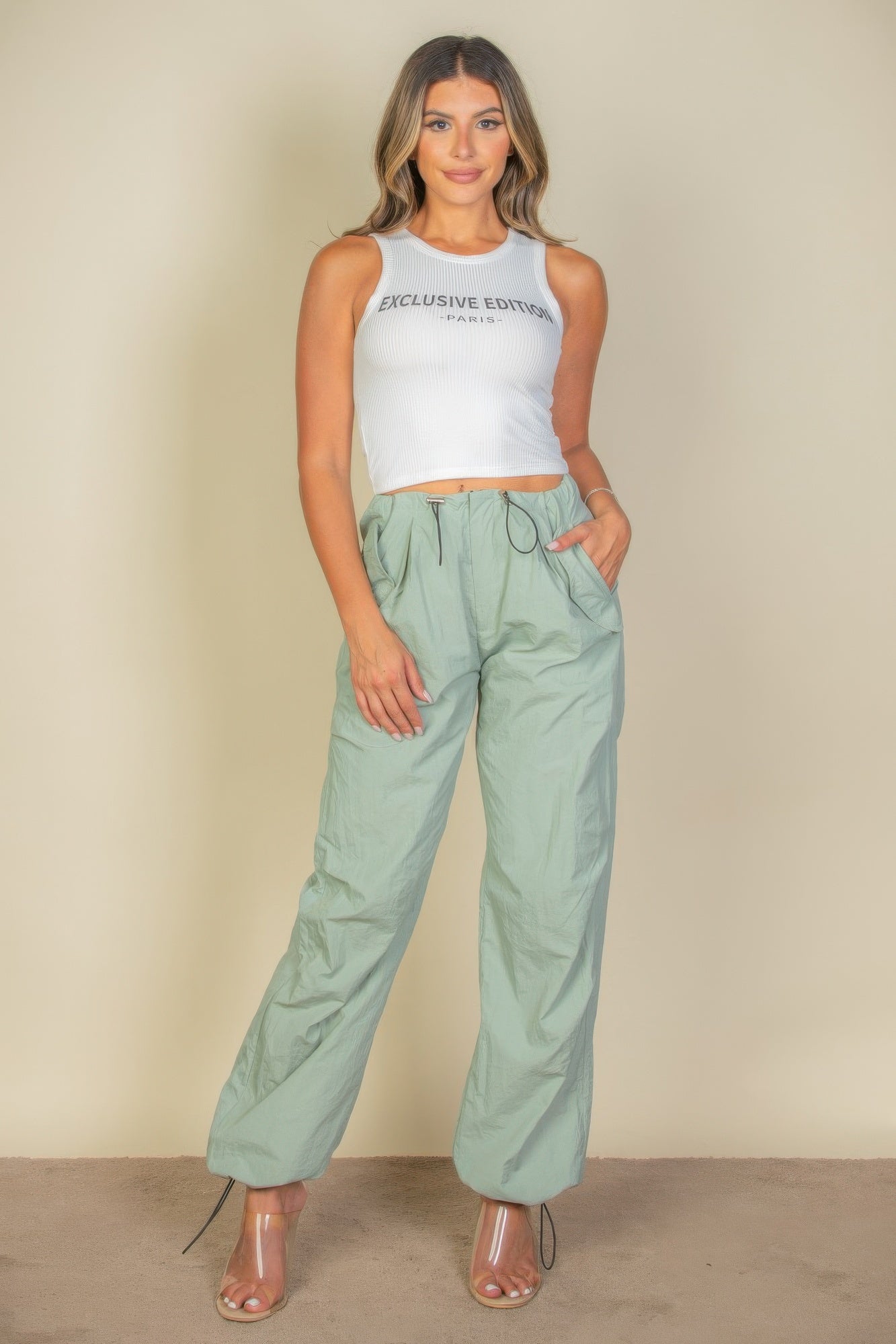 Full front view of the white Exclusive Edition Rib Tank Graphic Top styled with mint green trousers
