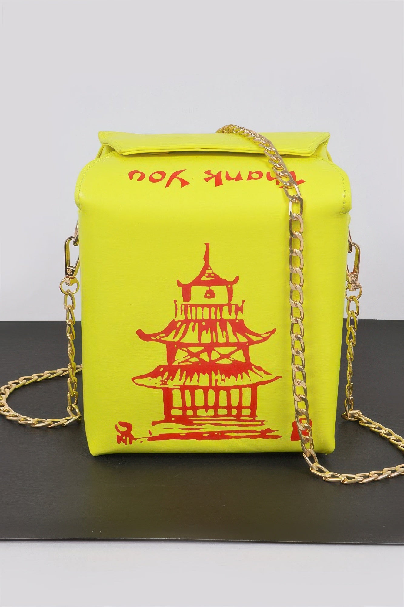 Neon yellow Chinese To Go Box Clutch front view with red pagoda graphic