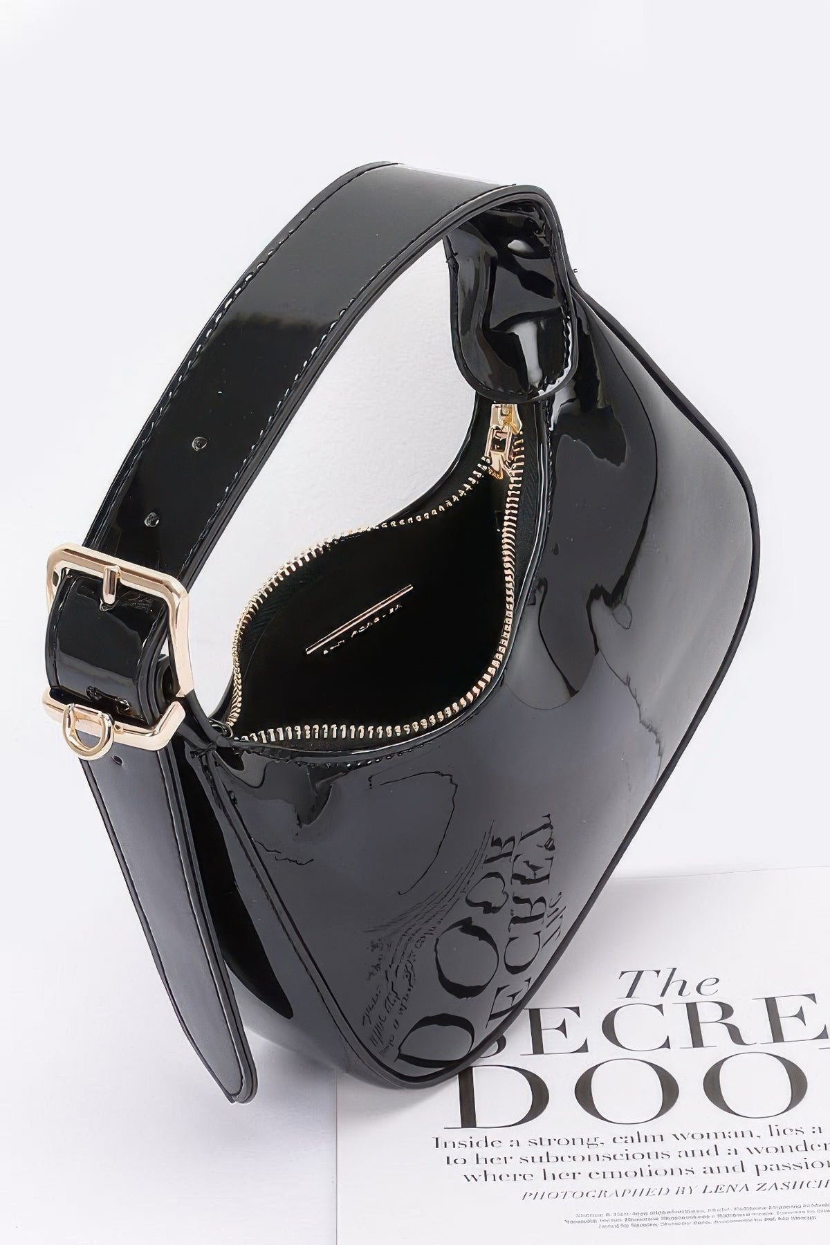 Open black Enamel Hobo Bag showing gold-tone zipper, interior and adjustable shoulder handle