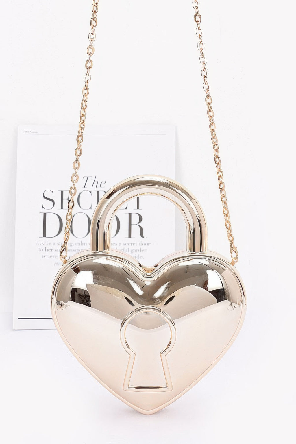 Gold heart-shaped Metallic Acrylic Bag with rounded top handle, keyhole motif and chain strap, front view