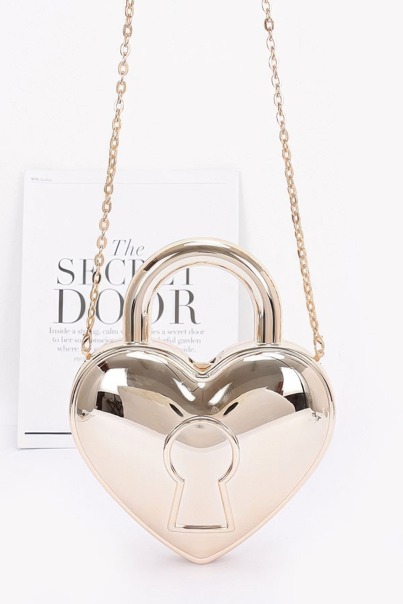 Gold heart-shaped Metallic Acrylic Bag with rounded top handle, keyhole motif and chain strap, front view