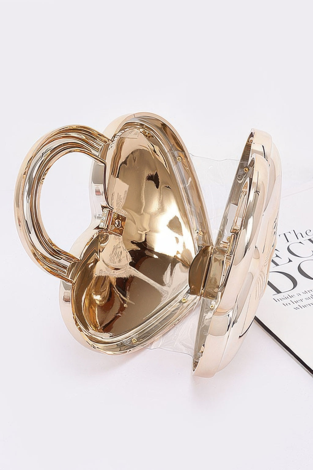 Open gold Metallic Acrylic Bag showing rigid heart-shaped interior, hinge and clasp construction