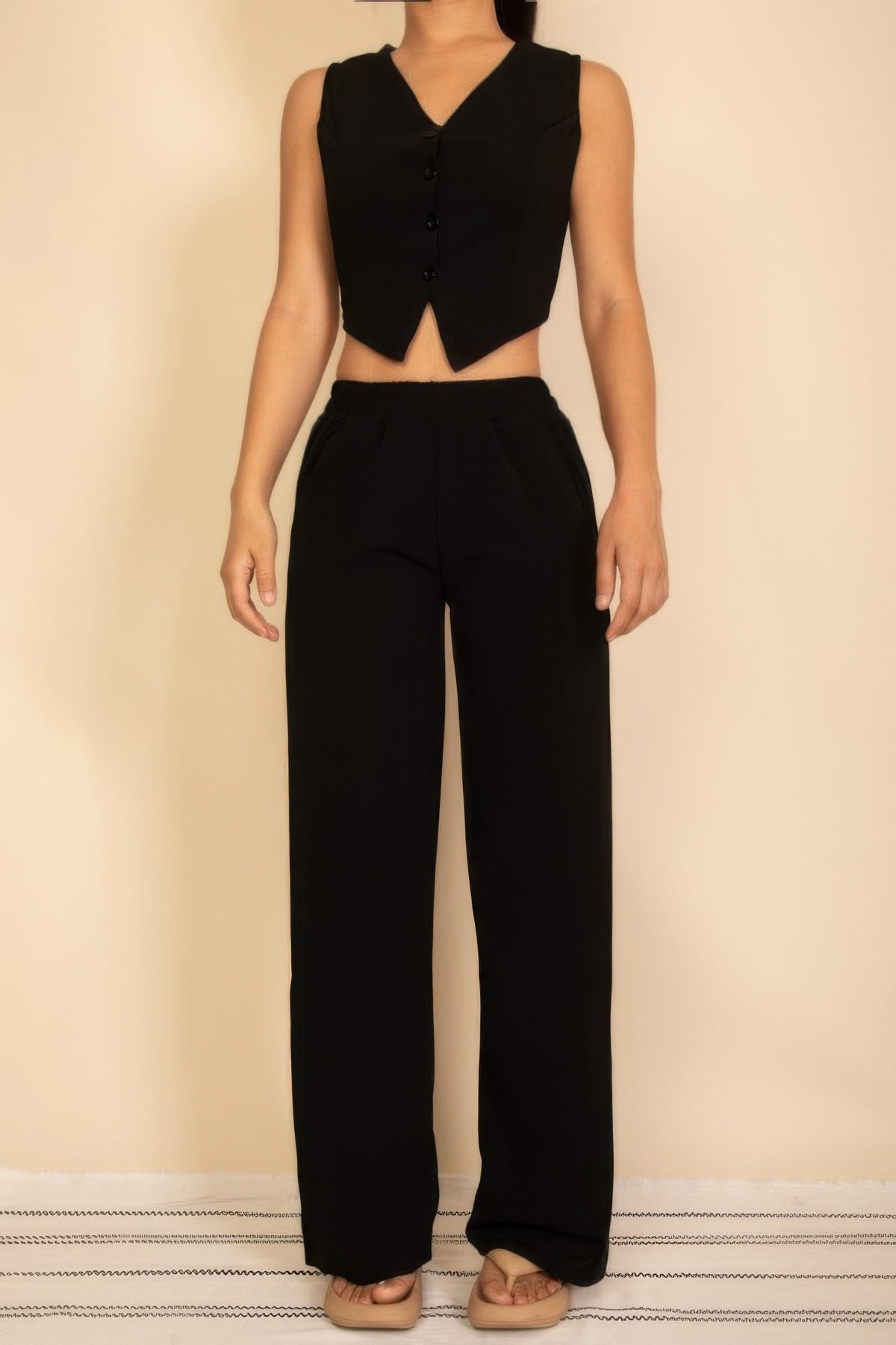 Black sleeveless four-button V-neck vest and matching wide-leg pants, full front view