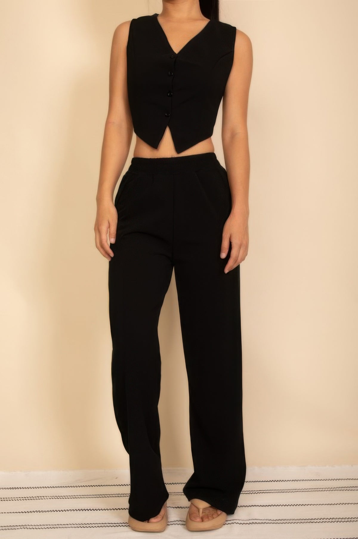 Black tailored vest and wide-leg pants set showing the high waist and front shaping seams