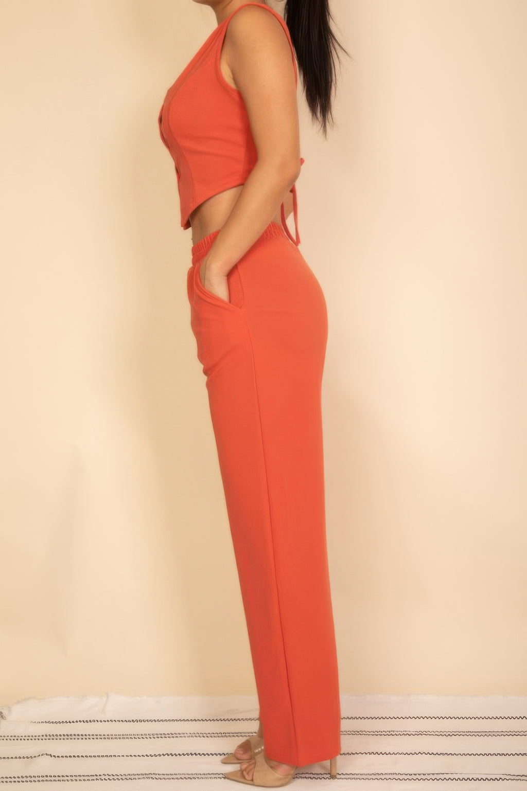 Rust tailored vest and wide-leg pants set showing the curved side pocket, side view