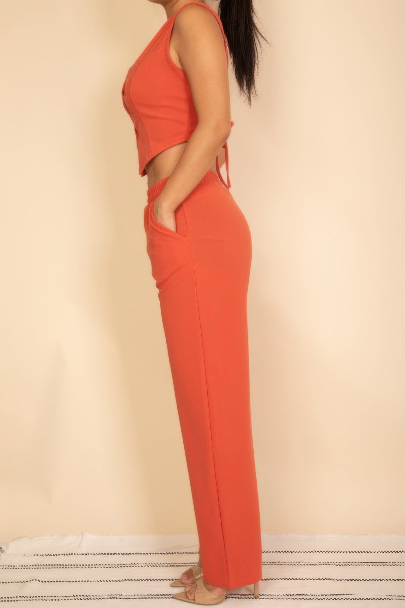 Rust tailored vest and wide-leg pants set showing the curved side pocket, side view