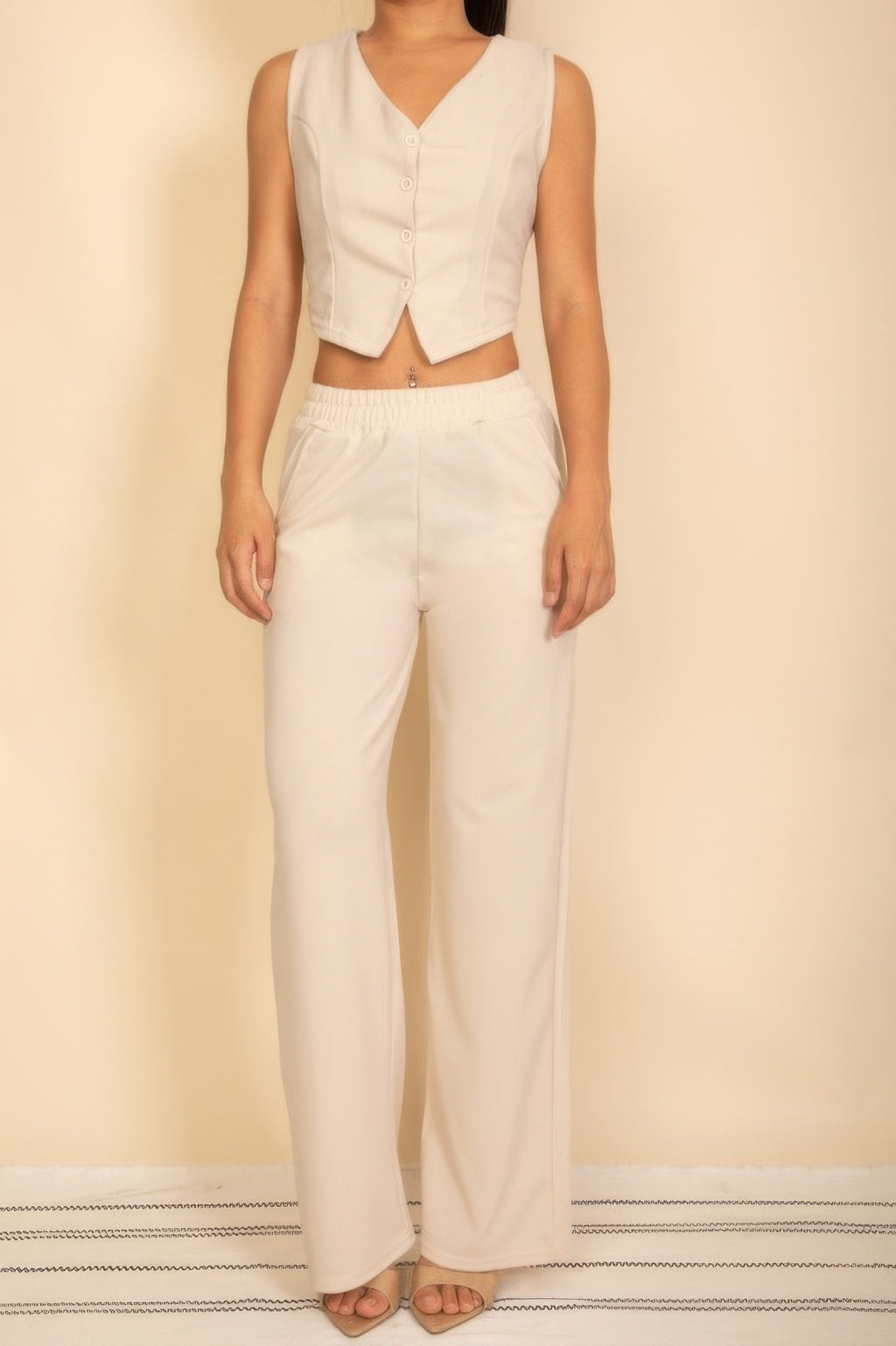 Ivory sleeveless four-button V-neck vest and matching elastic-waist wide-leg pants, full front view