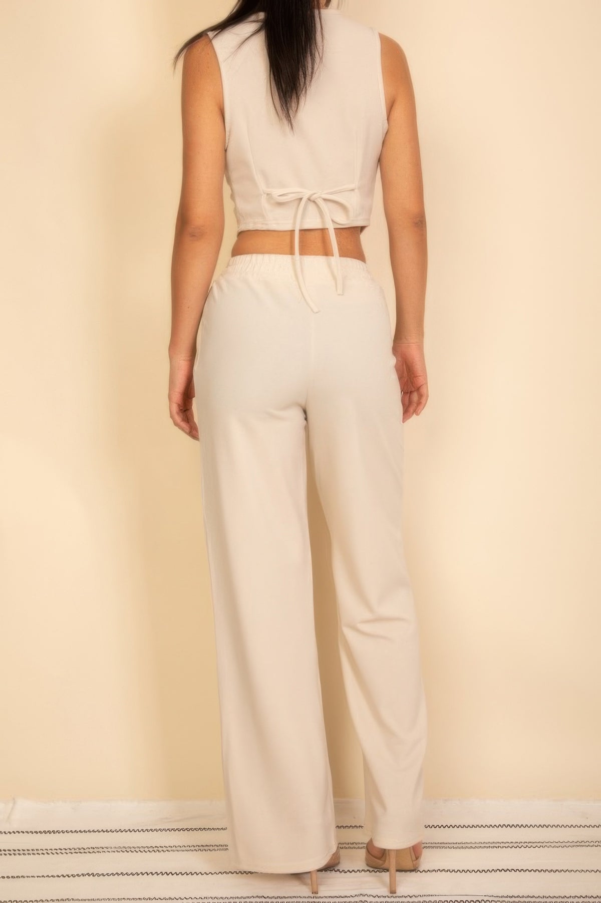 Ivory vest showing adjustable back bow tie with matching wide-leg pants, full rear view