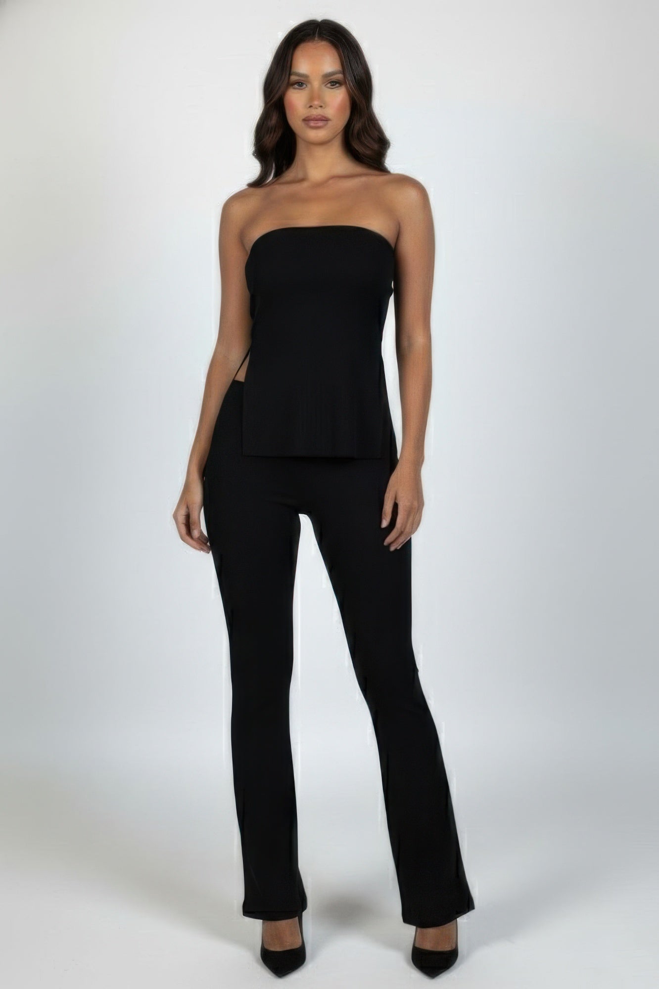 Front view of the black strapless ribbed slit tube top and high-waist flare pants set