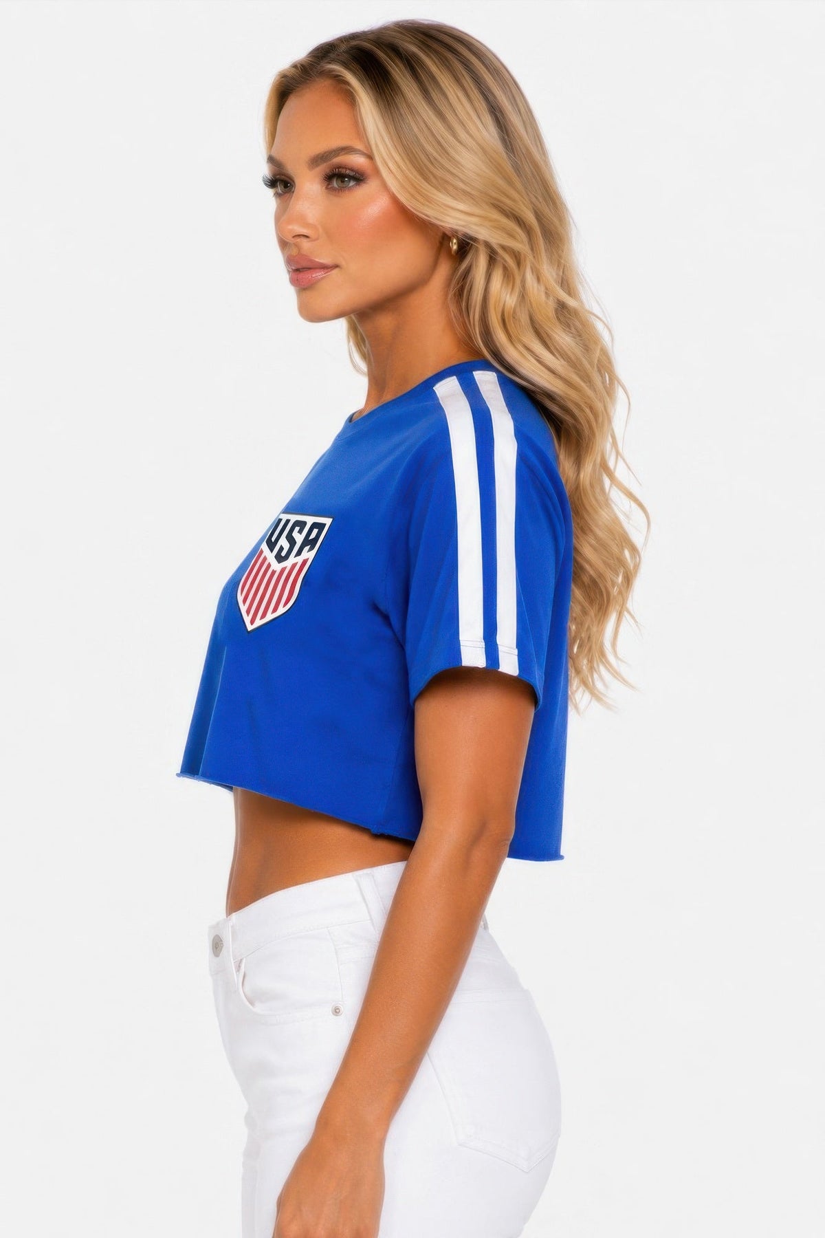 Model wearing the royal blue Victory Lap Cropped USA Tee, side view showing the raw hem and white sleeve stripes