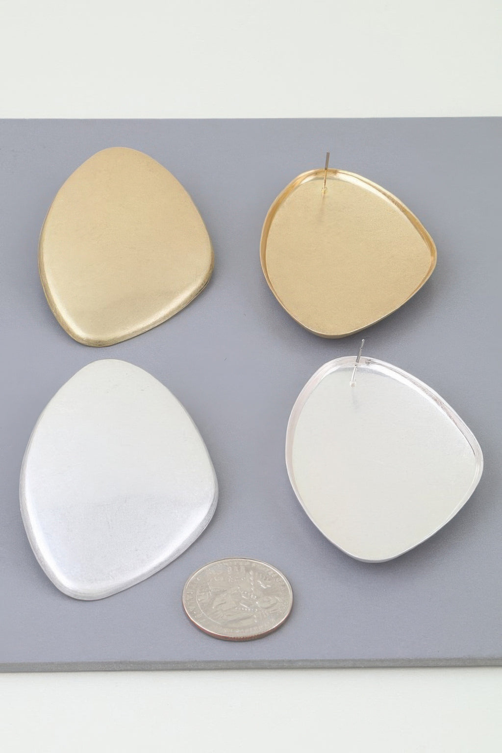 Gold- and silver-tone Power Plate earrings shown together for scale