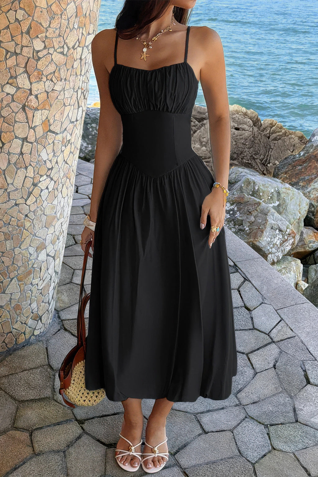 Black spaghetti-strap A-line dress showing the pointed basque waist