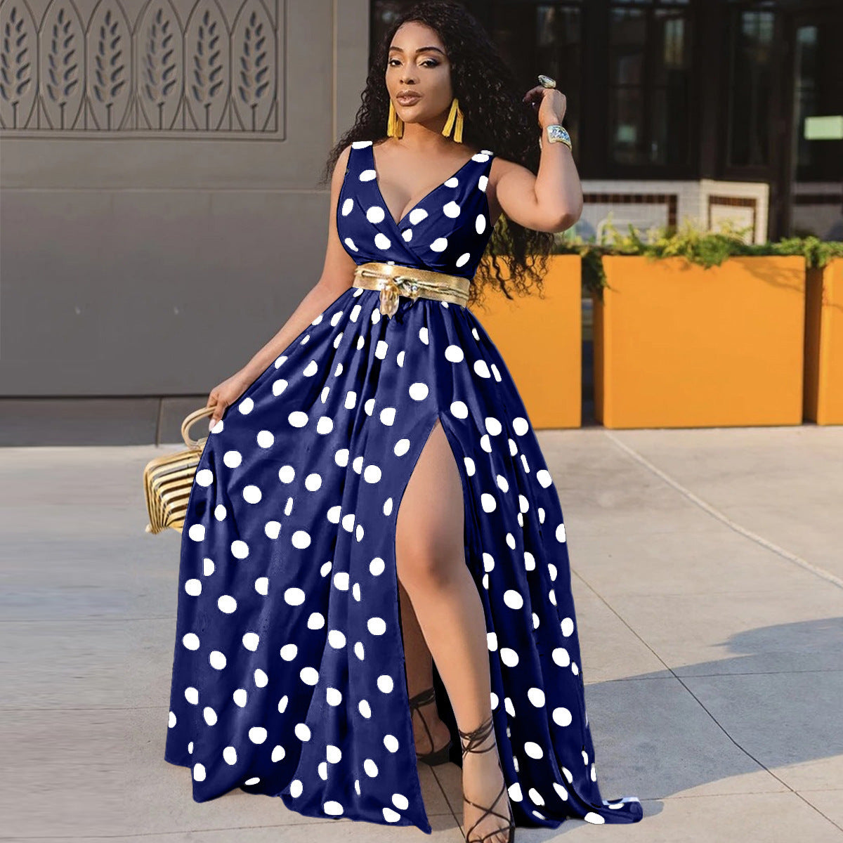 Adult model wearing the blue-and-white polka-dot sleeveless maxi dress with full skirt and front opening; belt is styling only.